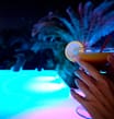 Les Mouettes campsite - The water park - Close up of a cocktail with the Blue Lagoon by night in the background