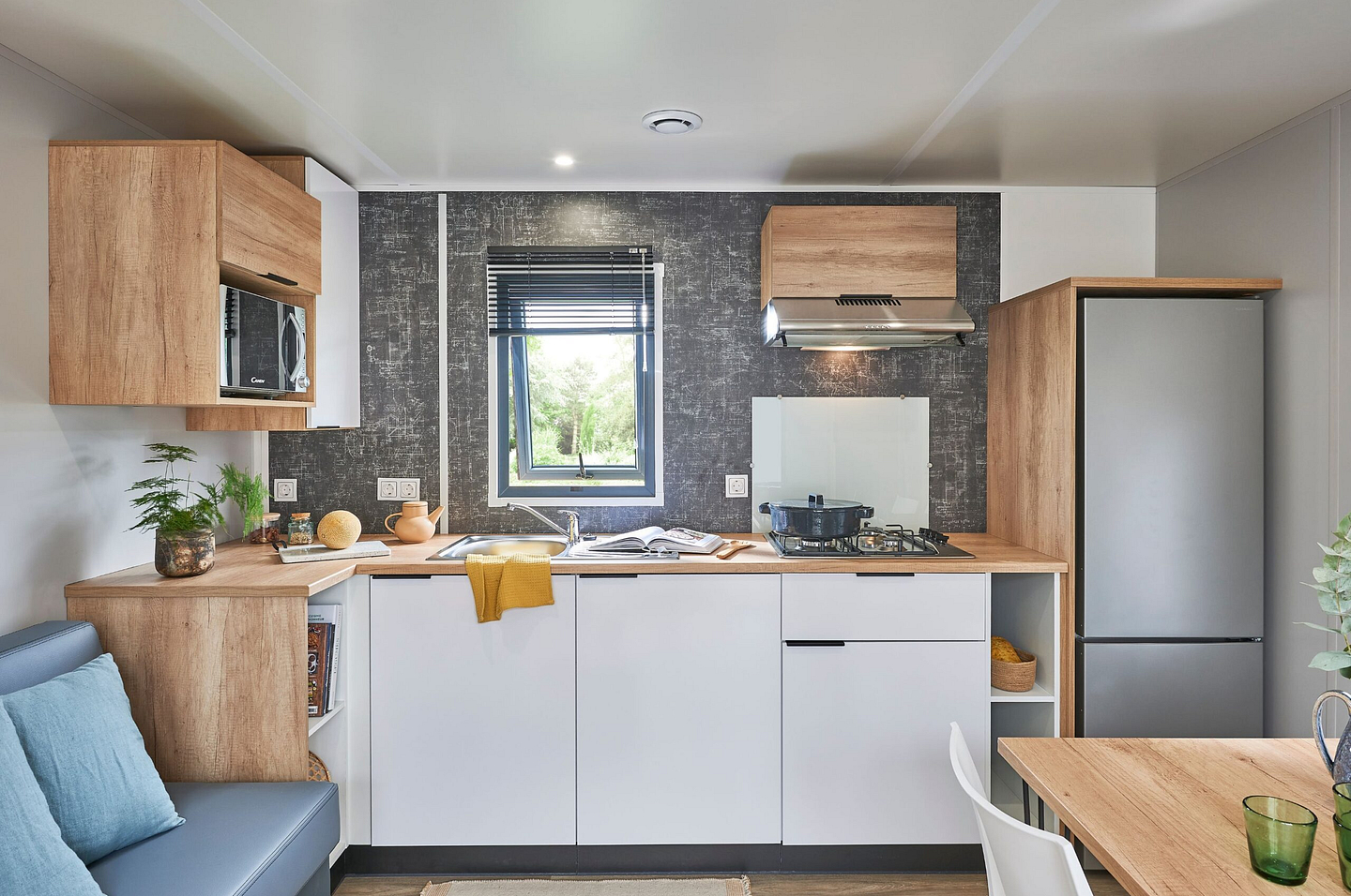 Cuisine moderne et enti&egrave;rement &eacute;quip&eacute;e du Cottage Confort Premium 2 chambres et 2 salles de bain au camping Domaine de Mesqueau, avec bardage bois et terrasse XXL dans un village pi&eacute;tonnier.\"