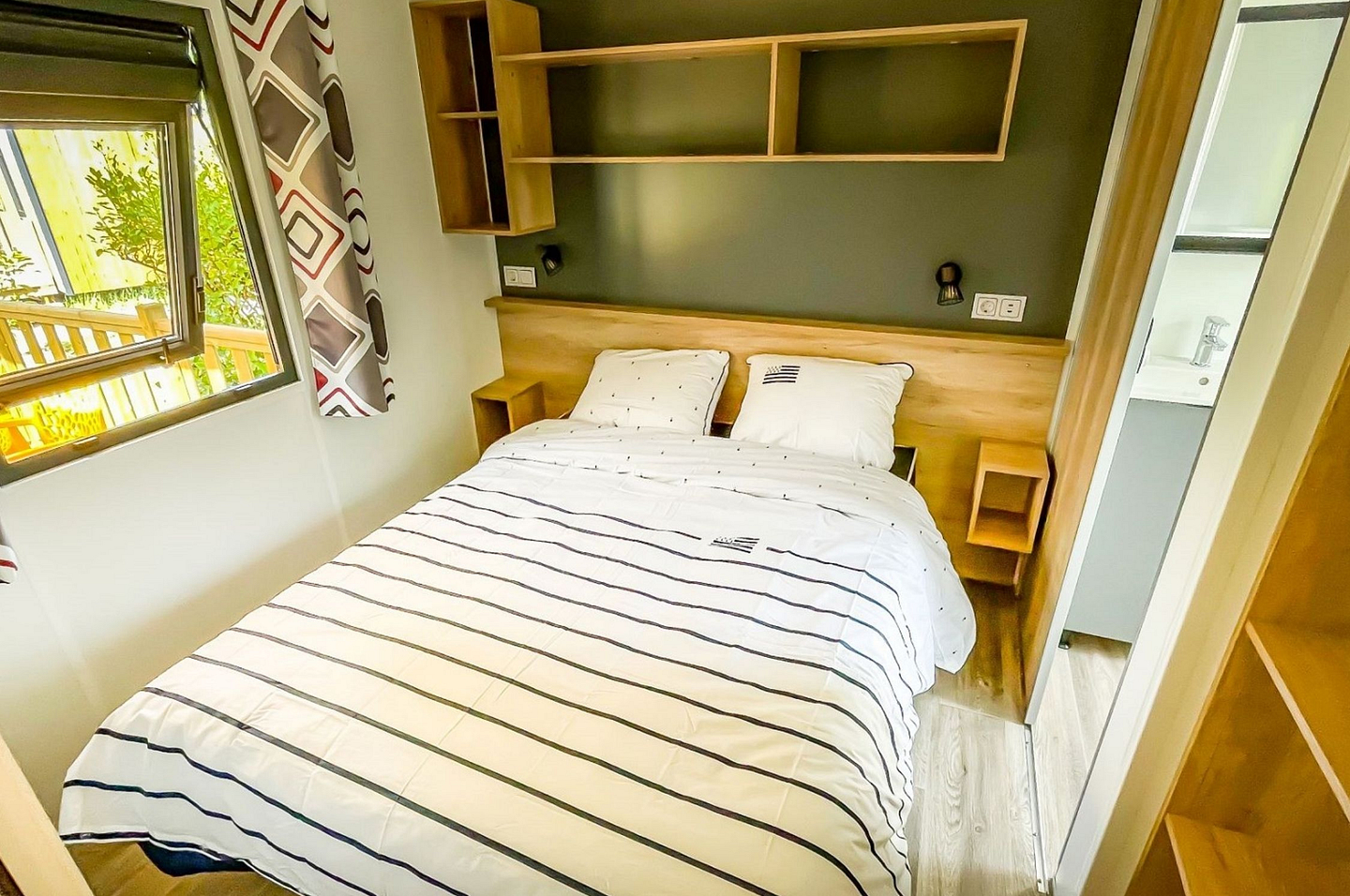 Suite parentale des cottages Confort Premium 3 chambres avec lit double et salle de bain équipée privative au camping Domaine de Mesqueau.