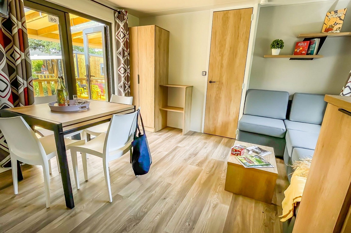 Salon lumineux avec TV et espace repas des cottages Confort Premium 3 chambres au camping Domaine de Mesqueau.