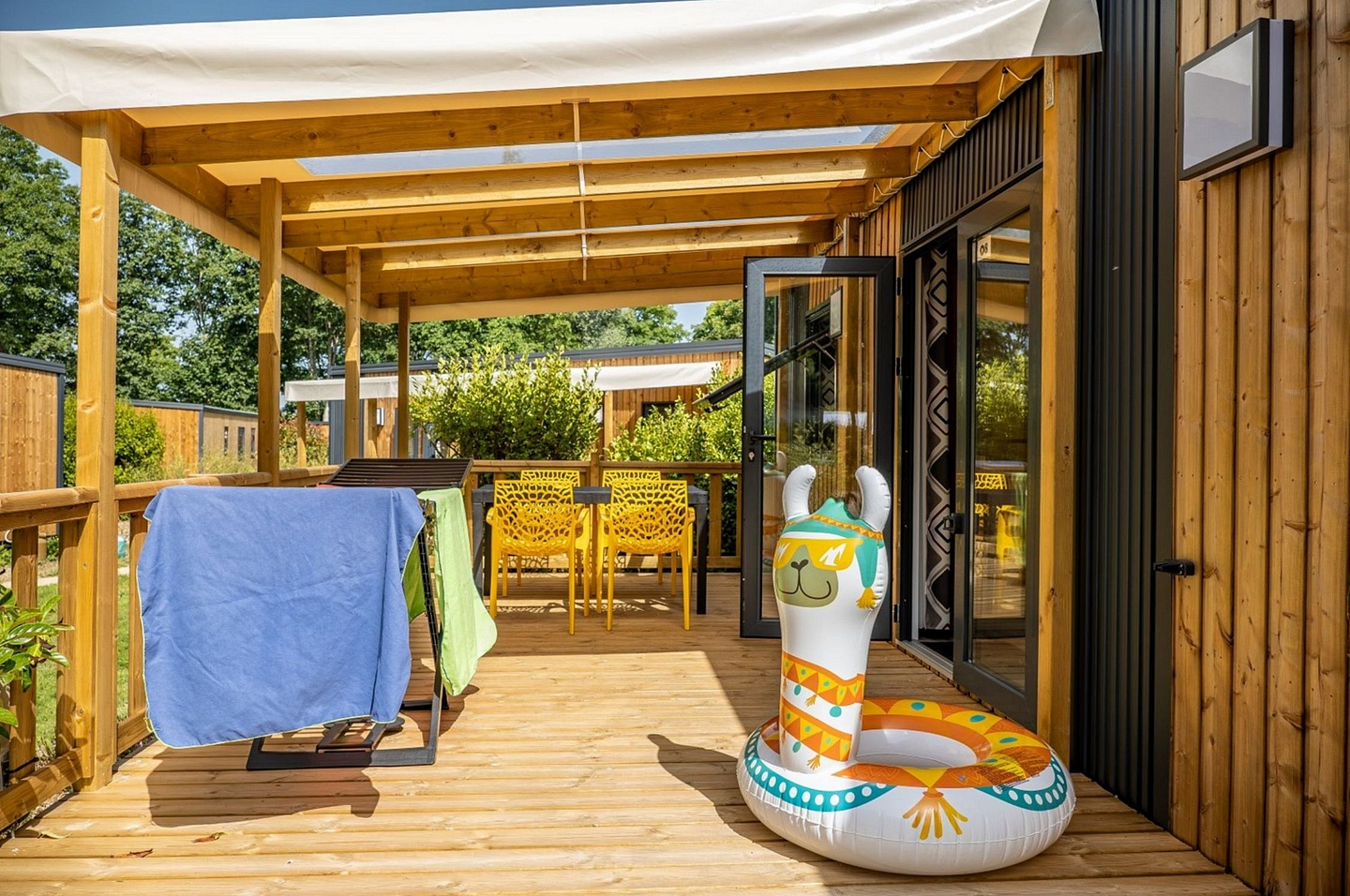 Terrasse XXL de 21m² des cottages Premium avec vue sur parc paysager au camping Domaine de Mesqueau.