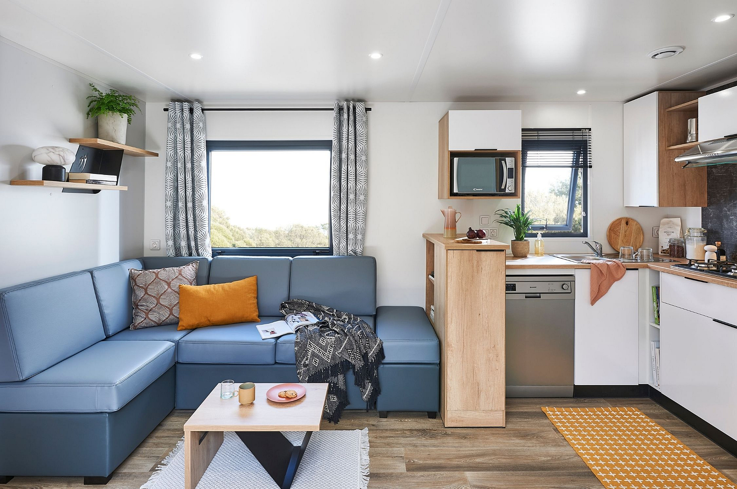 Int&eacute;rieur lumineux et moderne d&rsquo;un Lodge Premium au Domaine de Mesqueau, camping 4 &eacute;toiles en Bretagne, avec salon spacieux et cuisine &eacute;quip&eacute;e.