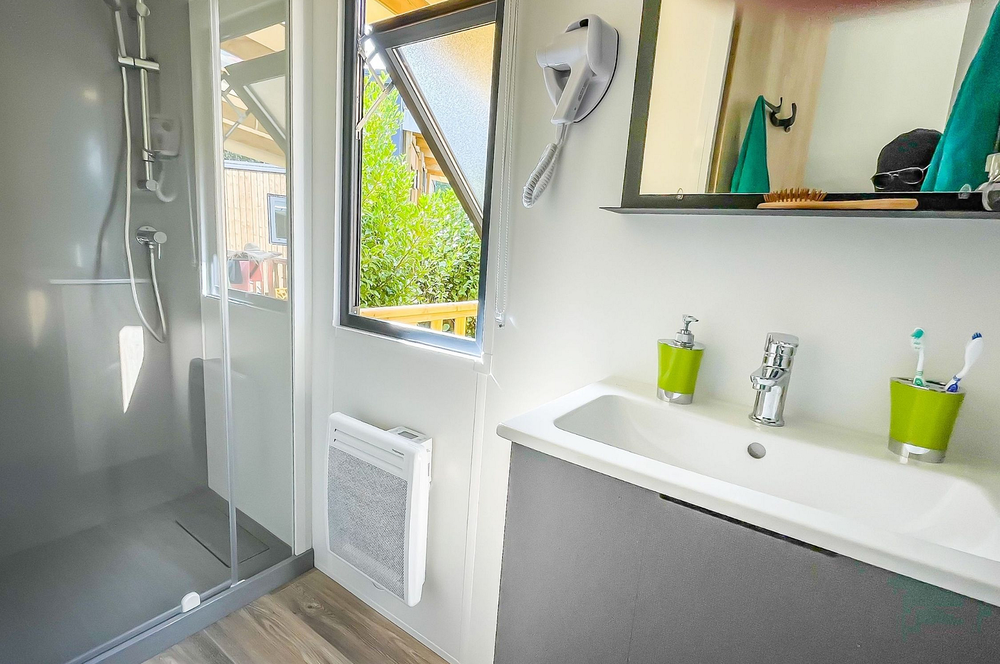 Salle de bain moderne &eacute;quip&eacute;e d\'une douche, s&egrave;che-cheveux et chauffage dans un Lodge Premium au Domaine de Mesqueau.