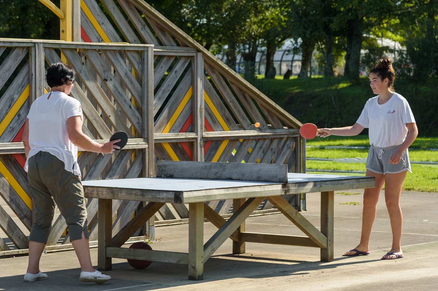 Deux vacanci&egrave;res jouant au ping-pong dans les installations ext&eacute;rieures du camping Domaine de Mesqueau &agrave; Plougasnou.