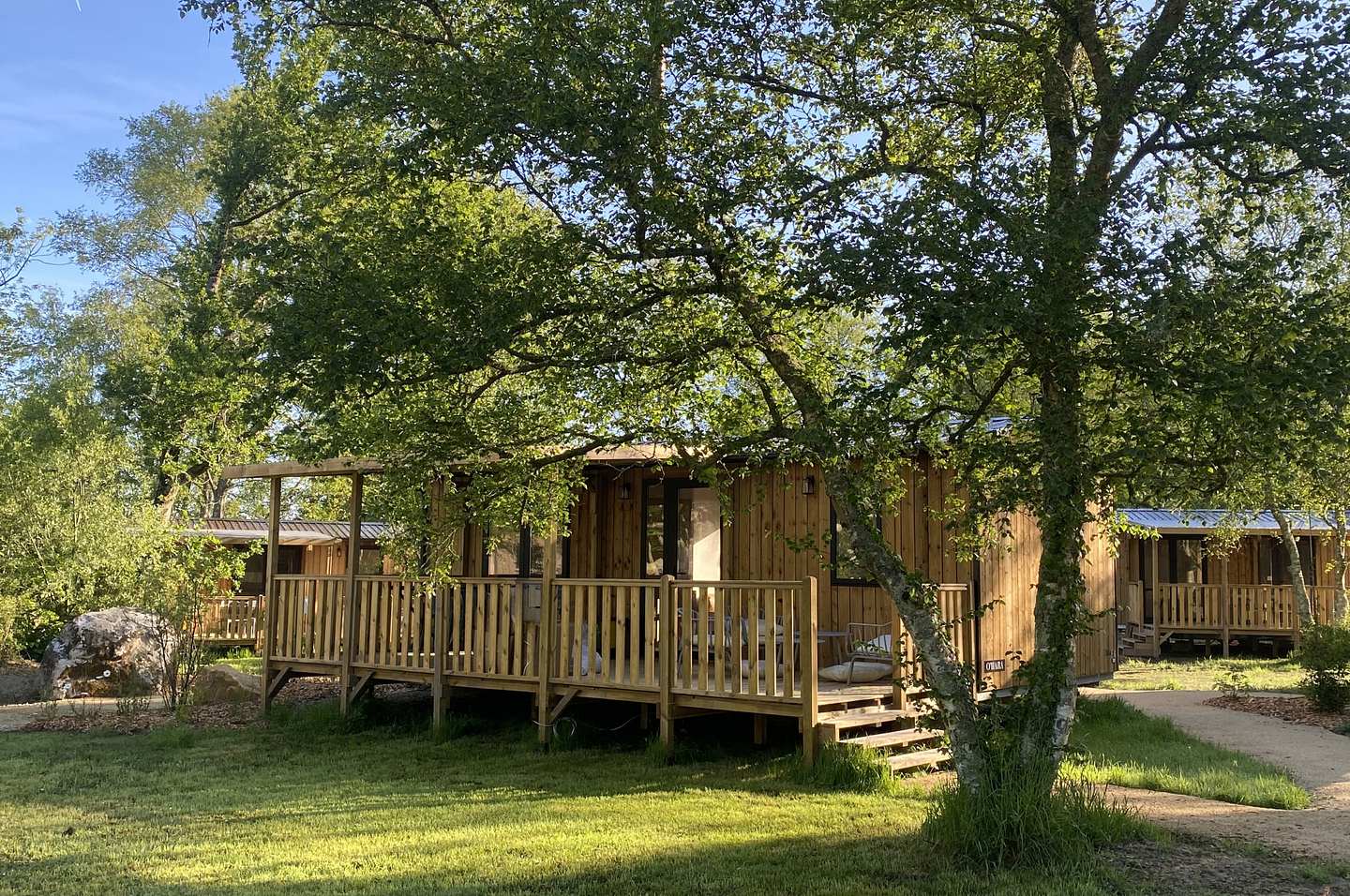 Lodge Ô COZY 804 en bardage bois avec terrasse semi-couverte au cœur d\'un environnement arboré du Domaine de Mesqueau.