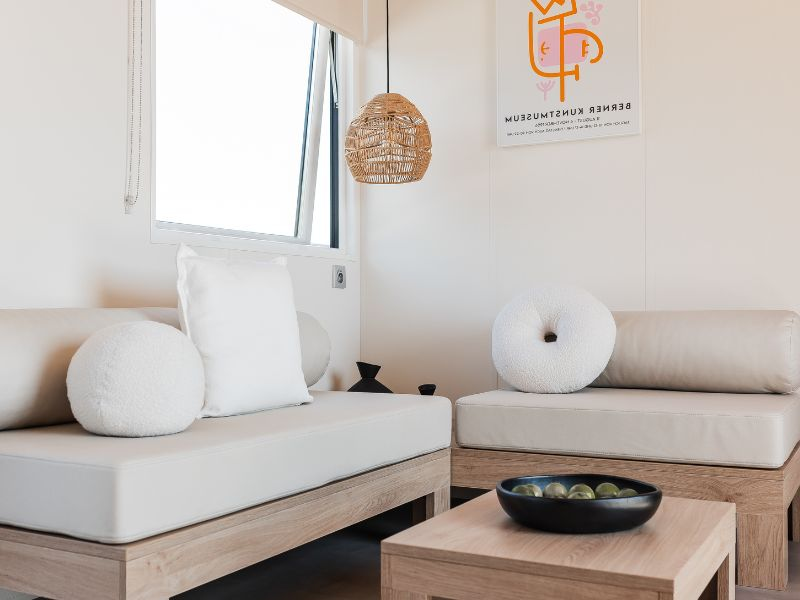 salon du nouveau Lodge &Ocirc; Grand Large de 40 m&sup2; avec terrasse couverte, h&eacute;bergement premium 3 chambres au camping Mesqueau