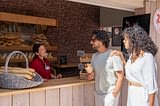Camping Le Logis - Services - Couple buys bread at the bakery