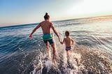 Le Moténo - Morbihan - Homme et son fils qui se baignent dans la mer