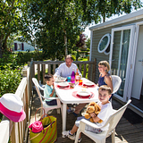 Campingplatz Le Ridin Le Crotoy, Unterkünfte, eine Familie, die auf der Terrasse ihres Mobilheimes frühstückt