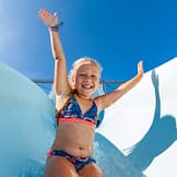 Camping Les Mouettes - Le parc aquatique - Gros plan d\'une enfant sur le toboggan