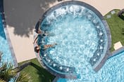 Camping Le Logis - Le Parc aquatique - Couple qui se détend sur les banquettes hydromassantes