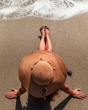 Domaine de Bagheera, Strand, auf dem Sand sitzt eine Frau