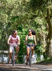 Camping Le Logis - Activités et animations - Couple qui se balade en vélo dans les allées du camping