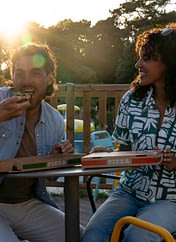 Le Logis Campsite - Services - Couple eating pizza on the terrace bar at the snack bar