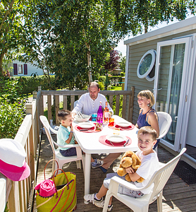 Campingplatz Le Ridin Le Crotoy, Familie, die auf der Terrasse eines Cottages frühstückt