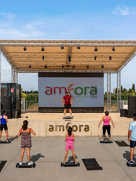 Camping Amfora - Activités et animations - Coach de fitness donnant un cours sur la scène du camping