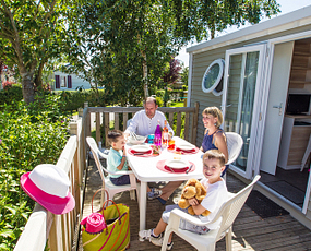 Campingplatz Le Ridin Le Crotoy, Familie, die auf der Terrasse eines Cottages frühstückt