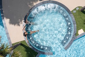 Camping Le Logis - Le Parc aquatique - Couple qui se détend sur les banquettes hydromassantes