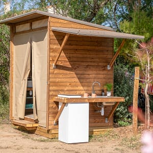 Camping Beauregard Plage - Emplacement Sani Lodge - Vue des sanitaires et de la cuisine extérieure