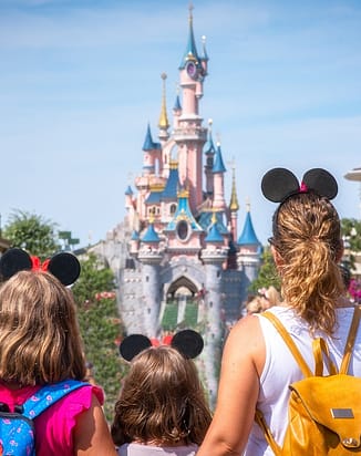 A mother and daughters admiring the princess castle at Disneyland