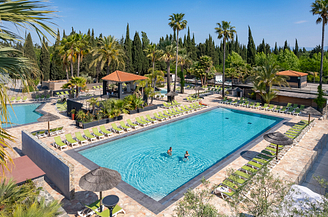 Luftaufnahme der Badelandschaft und eines Pärchens, das im Pool schwimmt - Campingplatz Fréjus Ecolodge L‘Etoile d\'Argens