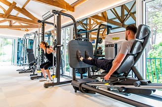Camping Le Bois de Valmarie - Espacio bienestar - Pareja musculándose en la sala de fitness
