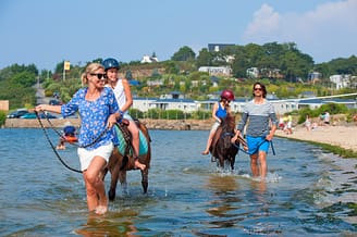 Camping Les Mouettes - Activités et animations - Promenade en famille en poney sur la plage