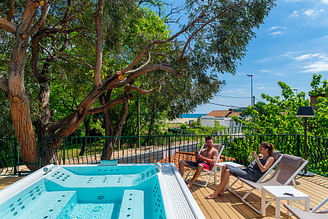 Camping Le Bois de Valmarie - Espacio bienestar - Pareja sentada en la terraza del baño de espuma