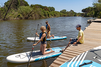 Pärchen, das an einem Stand-Up-Paddling-Kurs im Wassersportzentrum teilnimmt - Campingplatz Fréjus Ecolodge L‘Etoile d\'Argens