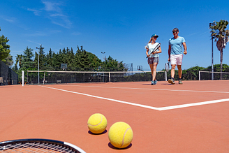Couple souriant sur le cours à la fin d\'un match de tennis - Camping Fréjus Ecolodge L\'Etoile d\'Argens