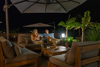 Camping Les Couleurs de la Coubre - Services - Couple qui boit une tisane sur la banquette de la terrasse
