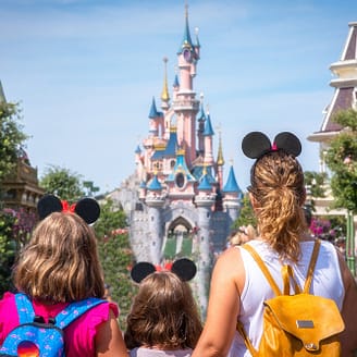 Une mère et ses filles contemplent le château de princesse du parc Disneyland - Disneyland® Paris