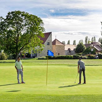 Deux golfeurs devant un ancien corps de ferme - Golf Crécy-la-Chapelle - Domaine de Crecy