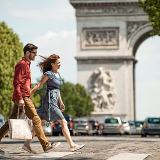 Paar beim Einkaufen auf der Avenue des Champs Elysée mit dem Triumphbogen im Hintergrund - Paris