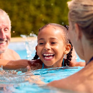 Grands parents jouant avec leur petite fille dans la piscine - Camping Country Park Crécy-la-Chapelle