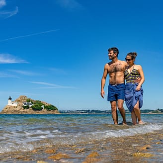 Camping Les Mouettes - Couple qui se promène les pieds dans l\'eau devant l\'Ile Callot