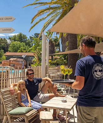 Camping la Sirène - Bars et restaurants - Homme et sa fille à la terrasse du Sirène Beach et serveur avec 2 boissons