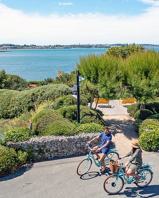 Camping Les Mouettes - Couple cycling on the campsite paths