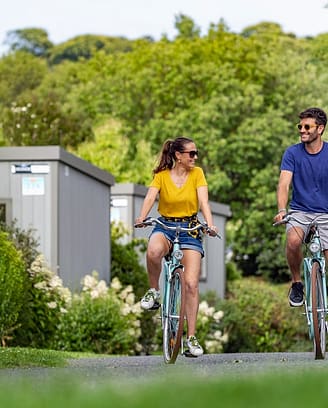 Campingplatz Les Mouettes - Mietunterkünfte - Paar auf dem Fahrrad in den Alleen