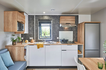 Cuisine moderne et enti&egrave;rement &eacute;quip&eacute;e du Cottage Confort Premium 2 chambres et 2 salles de bain au camping Domaine de Mesqueau, avec bardage bois et terrasse XXL dans un village pi&eacute;tonnier.\"
