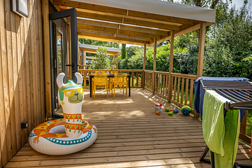 Terrasse XXL en bois donnant sur un parc paysager dans une zone 100% sans voiture au camping Domaine de Mesqueau.