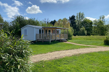 Mobil-home Simply Riviera 3 chambres pour 6 personnes au camping Domaine de Mesqueau &agrave; Plougasnou, entour&eacute; de verdure et sous un ciel bleu.