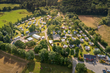 Vue a&eacute;rienne des h&eacute;bergements du Domaine de Mesqueau &agrave; Plougasnou, avec mobil-homes premium et espaces arbor&eacute;s, au c&oelig;ur d&rsquo;un cadre naturel pr&eacute;serv&eacute; en Bretagne.