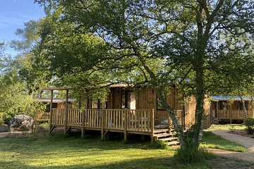 Lodge Ô COZY 804 en bardage bois avec terrasse semi-couverte au cœur d\'un environnement arboré du Domaine de Mesqueau.