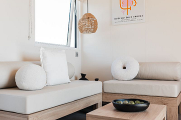 salon du nouveau Lodge &Ocirc; Grand Large de 40 m&sup2; avec terrasse couverte, h&eacute;bergement premium 3 chambres au camping Mesqueau