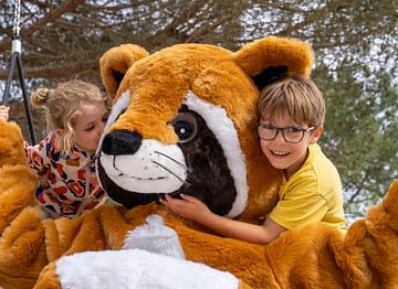Camping Les Couleurs de la Coubre - Activités et animations - Enfants dans les bras de la mascotte en peluche