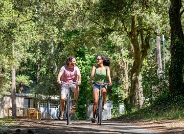 Camping Le Logis - Activités et animations - Couple qui se balade en vélo dans les allées du camping