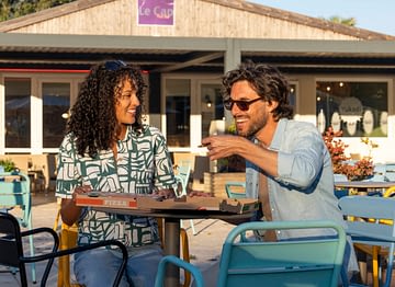 Camping Le Logis - Services - Couple qui mange une pizza à la terrasse du snack