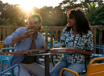 Le Logis Campsite - Services - Couple eating pizza on the terrace bar at the snack bar