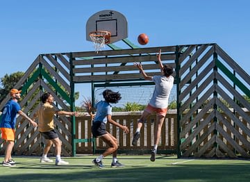 Camping Le Logis - Activités et animations - Groupe d\'amis qui font une partie de basket sur le terrain multisport